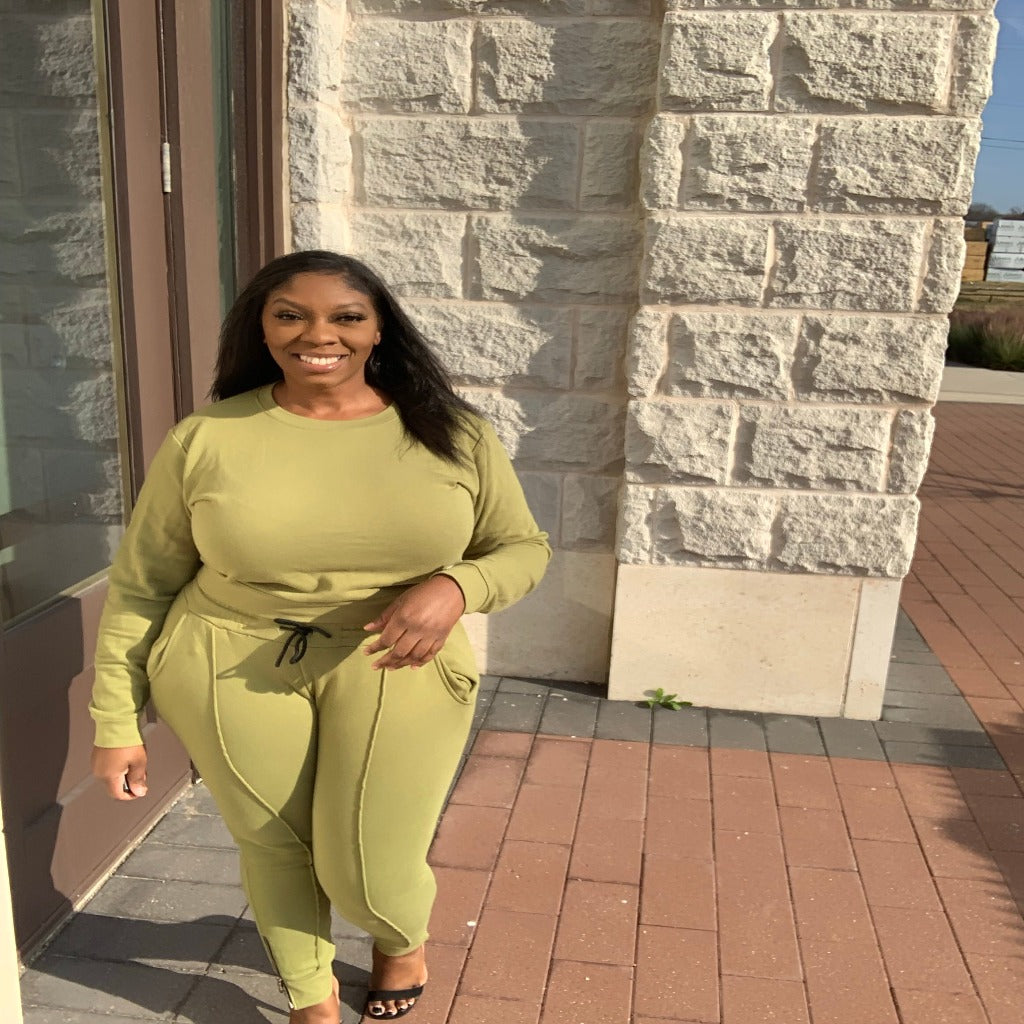 sweater and pants outfit in the color olive worn by curvy woman outside